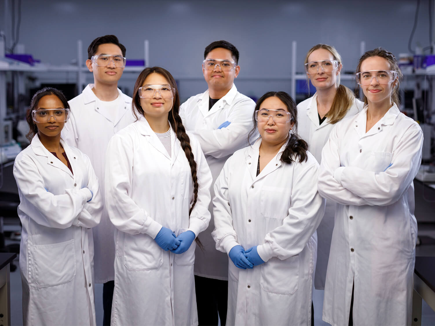 A team of Exact Sciences technicians wearing white lab coats and safety goggles.